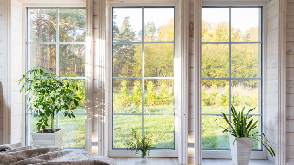 Helles Fotostudio-Interieur mit großem Fenster, hoher Decke und weißem Holzboden