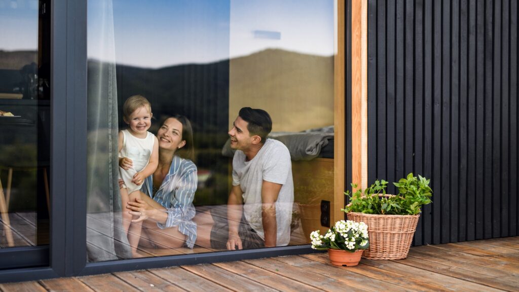Junge Familie mit kleiner Tochter zu Hause, Wochenendausflug in ein Containerhaus auf dem Land.